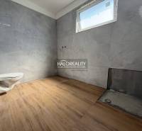 Koupelna v rodinném domě s dlažbou a volným WC, čeká na dokončení.