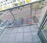 Balkon s výhledem na parkoviště a stromy z 3pokojového bytu.