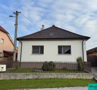 Rodinný dům v Trstíně se šikmou střechou, oplocení a travnatá plocha před domem.
