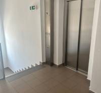 Schodiště a výtah ve 3-pokojovém bytě, čisté prostory s dlažbou.
