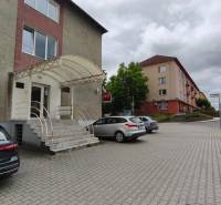 Budova s kancelářemi na ulici SNP ve Velkém Krtíši, parkování a vstupní schody.