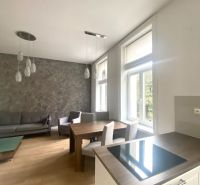 Obývací pokoj s kuchyňským koutem ve 3-pokojovém bytě s podlahou s dřevěným dekorem.