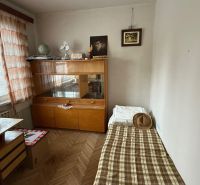 Pokoj s postelí, skříní a stolkem, v 3-pokojovém bytě s podlahou s dřevěným dekorem.