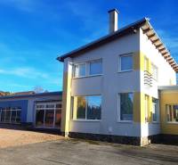 Rodinný dům v Necpalech, barevná fasáda, velký dvůr, slunečný jasný den.