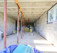 Stavba rodinného domu v Hontianske Tesáre s neomítnutými stěnami a podpěrnými sloupy.