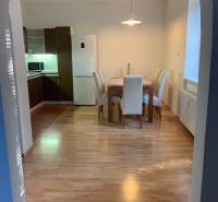 Jídelní kout s podlahou s dřevěným dekorem v 2-pokojovém bytě, stůl a čtyři židle.