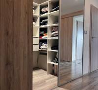 Vestavěná skříň s posuvnými dveřmi a podlaha s dřevěným dekorem v rodinném domě.