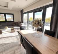 Obývací pokoj rodinného domu s podlahou s dřevěným dekorem a komfortním sezením.