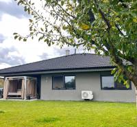 Rodinný dům na Lipové ulici v Dubové, strom a zelený trávník v popředí.