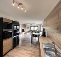 Kuchyně v rodinném domě s podlahou s dřevěným dekorem a praktickým sezením.