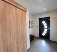 Vstupní chodba v rodinném domě s dlažbou a moderními dveřmi.