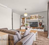 Obývací pokoj v 2-pokojovém bytě s podlahou s dřevěným dekorem, pohodlným sezením a dekoracemi.