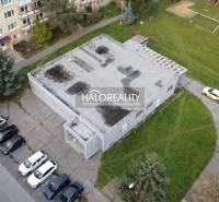 V Rimavské Sobotě jsou obchodní prostory obklopené paneláky a parkovacími místy.