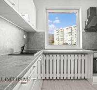 Kuchyně v 2pokojovém bytě s výhledem a podlahou s dřevěným dekorem.