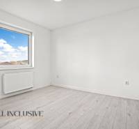 Pokoj v 2-pokojovém bytě s oknem a podlahou s dřevěným dekorem.