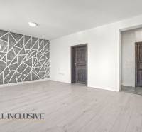 Obývací pokoj s podlahou s dřevěným dekorem a geometrickou stěnou v 2-pokojovém bytě.