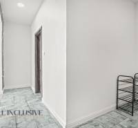 Chodba v 2-pokojovém bytě s podlahou s dřevěným dekorem a regálem na obuv.