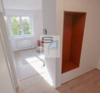 Chodba v 2-pokojovém bytě s podlahou s dřevěným dekorem a výhledem do místnosti.