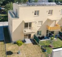 Žlutý bytový dům na Železniční ulici v Bratislavě-Vrakuni se zahradou a parkovacími místy.