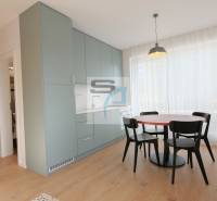 Jídelní kout se stolem a židlemi, vestavěnými skříňkami a podlahou s dřevěným dekorem.