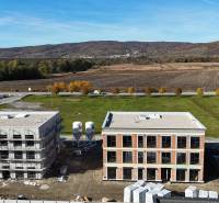 Stavební projekt na Duhové ulici ve Slovenském Grobu, obklopený přírodou a otevřenou krajinou.