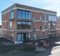 Novostavba na Duhové ulici ve Slovenském Grobu se zasklenými stěnami a parkovištěm.