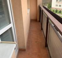 Balkon 2pokojového bytu s terakotovou dlažbou a výhledem na zeleň.