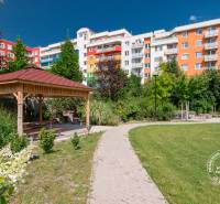 Na ulici Bosákova, zahrada s altánkem před bytovkou, láká k odpočinku.