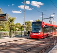 Na ulici Bosákova přijíždí červená tramvaj u 2pokojového bytu během slunečného dne.