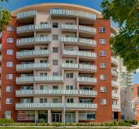 Výšková budova se zajímavými balkony u ulice Bosákova, blízko garáží ve městě.