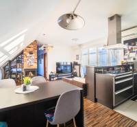 Kuchyně s televizorem, krbem a podlahou s dřevěným dekorem v 2-pokojovém bytě.