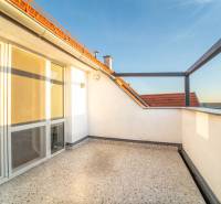 Sluneční terasa u 2pokojového bytu s výhledem na střechy a oblohu.