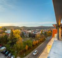 Pohled z Vajanského ulice v Modre na okolní krajinu a bytovou zástavbu.