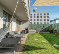 Zahradní terasa u 3pokojového bytu v Bratislavě - Lamači, Jána Langoše, s trávníkem a závěsy.