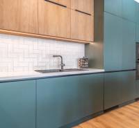 Kuchyně s tyrkysovými skříňkami, dřevěným dekorem a bílými obkladačkami, 3pokojový byt.