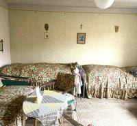 Pokoj v rodinném domě se třemi lůžky a stolkem, obložený dekory.