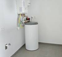 Rodinný dům s kotlem a zařízením na ohřev vody. Šedá podlahová krytina.