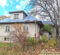 Rodinný dům v Liptovských Beharovcích, s plechovou střechou a okolní zelení.