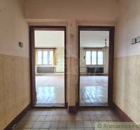 Interiér rodinného domu s podlahou s dřevěným dekorem a dvěma místnostmi.