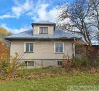 Rodinný dům v Liptovských Beharovcích obklopují stromy a keře na podzim.