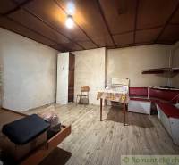 Interiér rodinného domu s lavicí a stolem, podlaha s dřevěným dekorem.