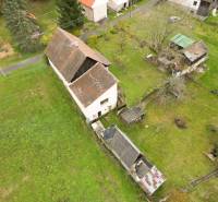 Rodinný dům na Sklené ve Sklené obklopený zahradou, s vedlejšími stavbami a stromy.