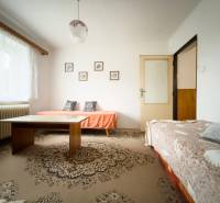 Obývací pokoj v rodinném domě se dvěma pohovkami a stolem na koberci.