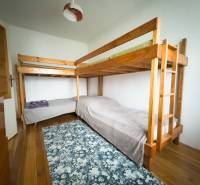 Palanda v rodinném domě s podlahou s dřevěným dekorem a vzorovaným kobercem.