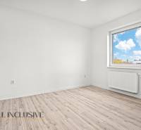 Světlý pokoj s podlahou s dřevěným dekorem a oknem v 2pokojovém bytě.