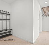 Chodba v 2-pokojovém bytě s věšákem na stěně a dlažbou na podlaze.