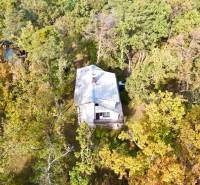 Chata ukrytá v lese u Gazárky v Šaštín-Strážích obklopená podzimní přírodou.