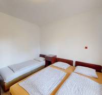 Ložnice v chatě s jedním samostatným a dvěma spojenými lůžky, prostor na odpočinek.