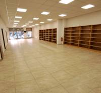 Obchodní prostory k pronájmu na Mostové ulici v Ružomberku, s regály a podlahou s dřevěným dekorem.