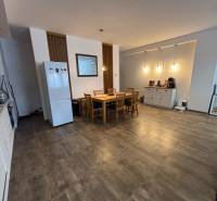 Jídelní kout v 2-pokojovém bytě se stolem a židlemi, podlaha s dřevěným dekorem.